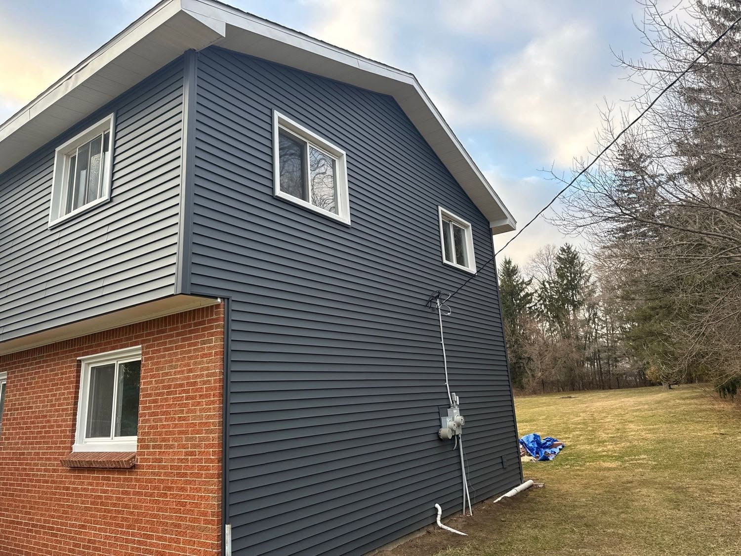 Blue residential siding installed by Walkers Quality Roofing